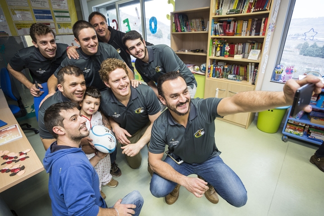 Selfie de los jugadores y técnico del UBU Colina Clinic con niños de la planta de Pedriatría del HUBU.