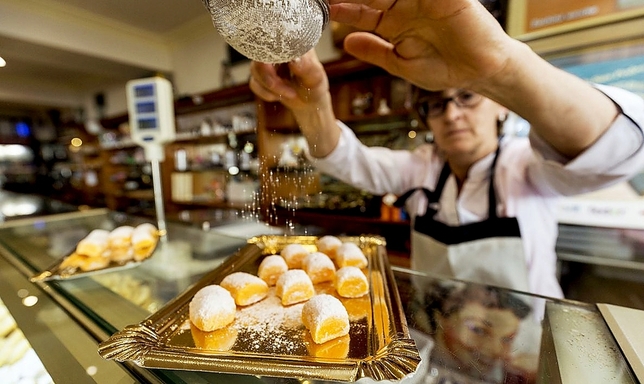 Milagros García glasea en la pastelería Silma las yemas de Burgos antes expedirlas al cliente.