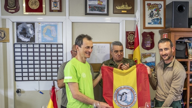 El ministro y el comandante Juan José Pereda (d.), con la bandera española y el logotipo de la Misión Antártica del Ejército de Tierra.