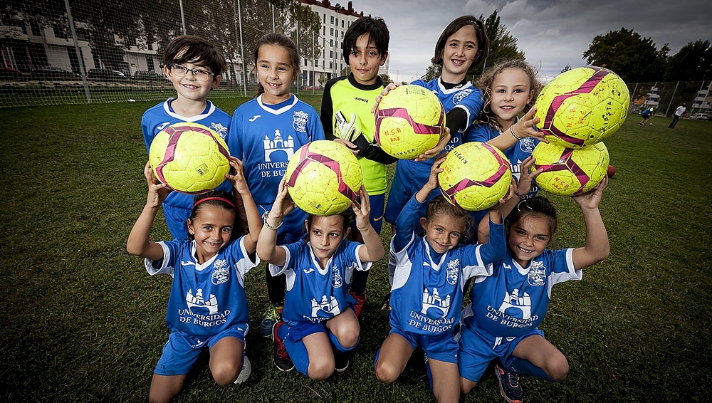 Las jugadoras de la categoría prebenjamín, escuadra de nueva creación, sujetan con una sonrisa los balones sobre el césped de los campos de la Universidad de Burgos.  / VALDIVIELSO