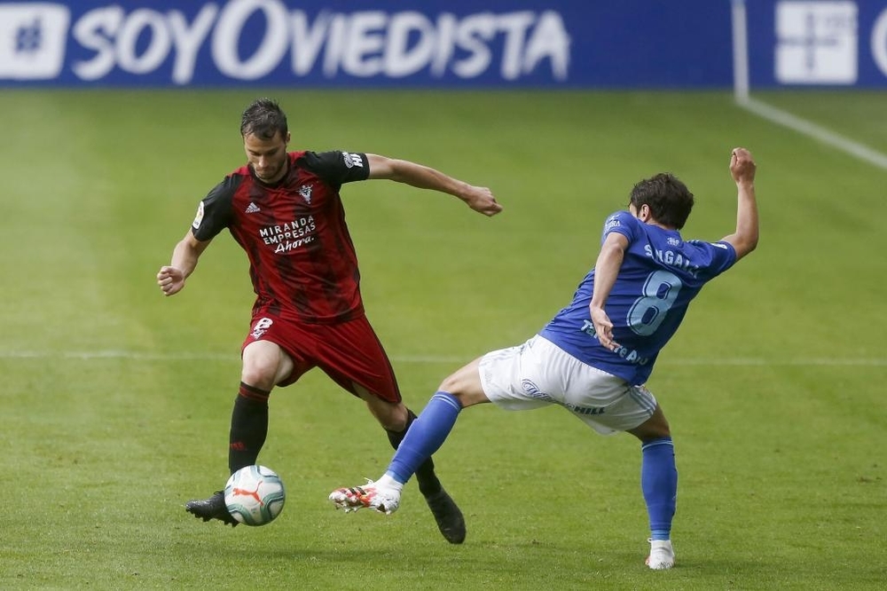 Crisetig, con el balón, salva la entrada de Sangalli, durante el encuentro entre Mirandés y Oviedo disputado en julio en el Tartiere. 