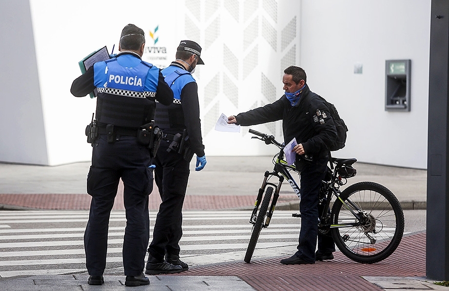 Policías locales piden la documentación a un ciclista en la calle San Lesmes. 