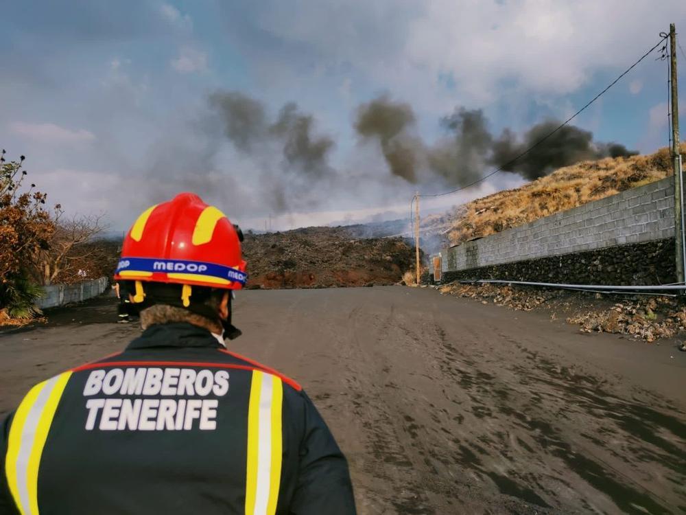 Un bombero del Consorcio de Bomberos de Tenerife vigila el avance de la colada sur en la isla de La Palma