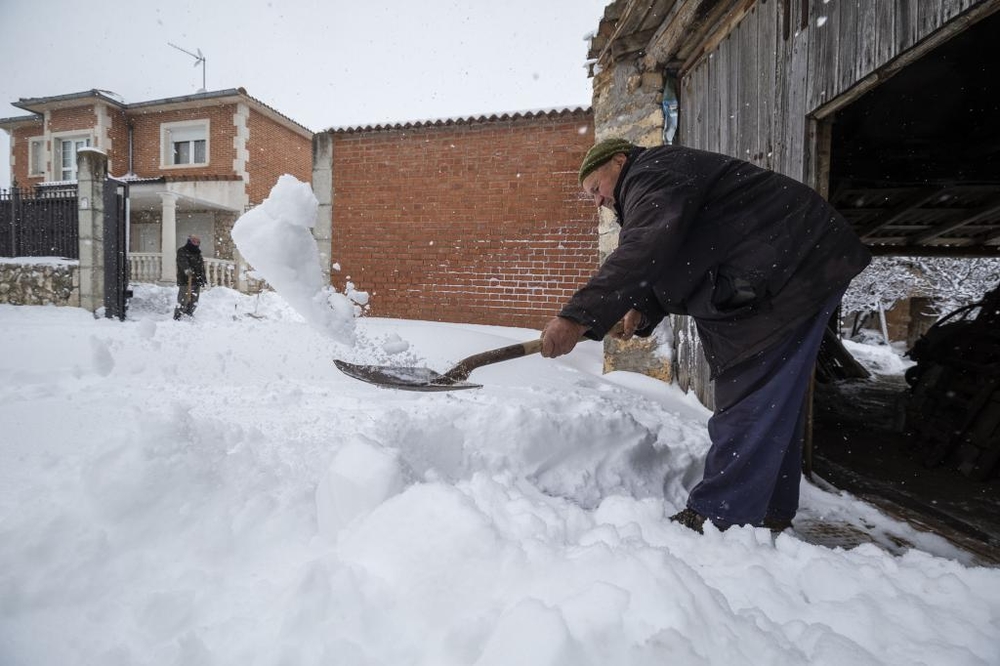 Los vecinos se afanaban en retirar la nieve de sus propiedades.   / ALBERTO RODRIGO