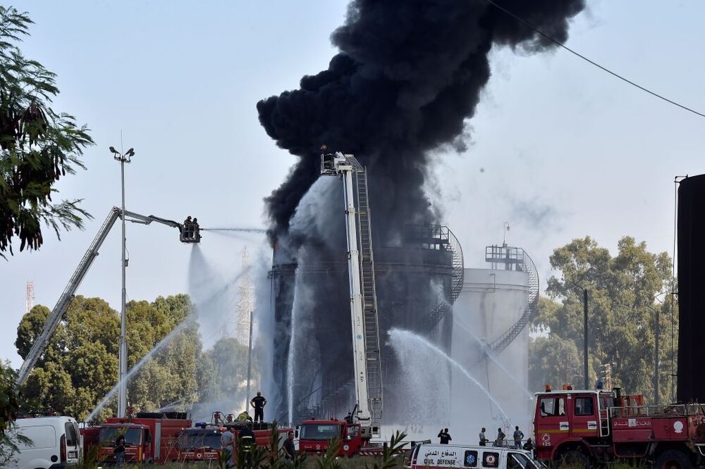 Los bomberos extinguen las llamas en uno de los tanques de combustible que contienen gasolina en Zahrani