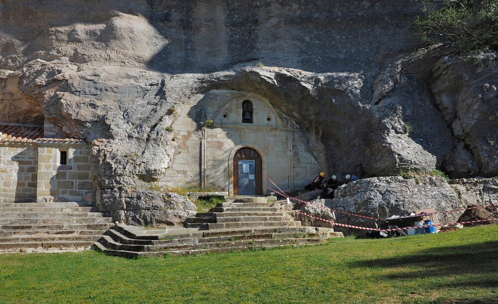 La tumba está empotrada en la roca junto a la entrada a la ermita de San Tirso y San Bernabé.