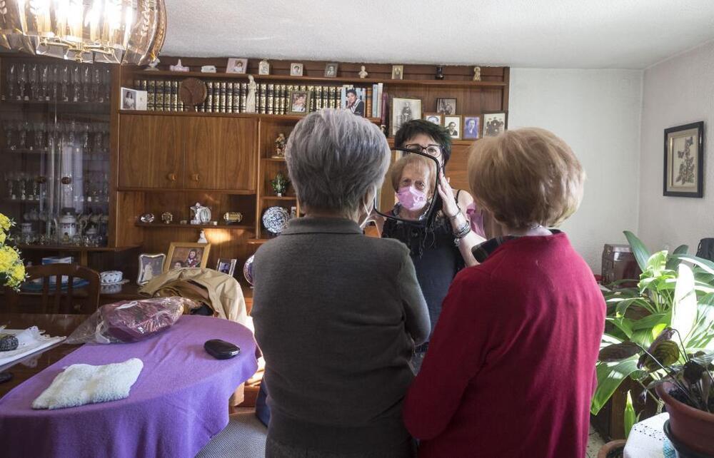 La peluquera, que es acogida en cada casa casi como un miembro de la familia, mostrando a dos de sus clientes el resultado.