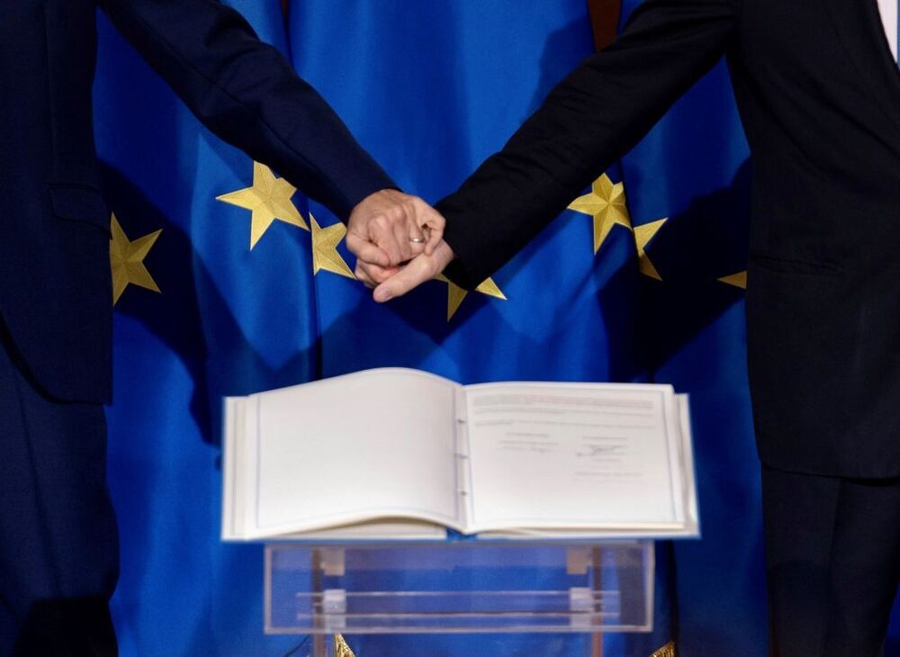 Macron (i) y Draghi se dan la mano tras la firma del acuerdo de Quirinal.