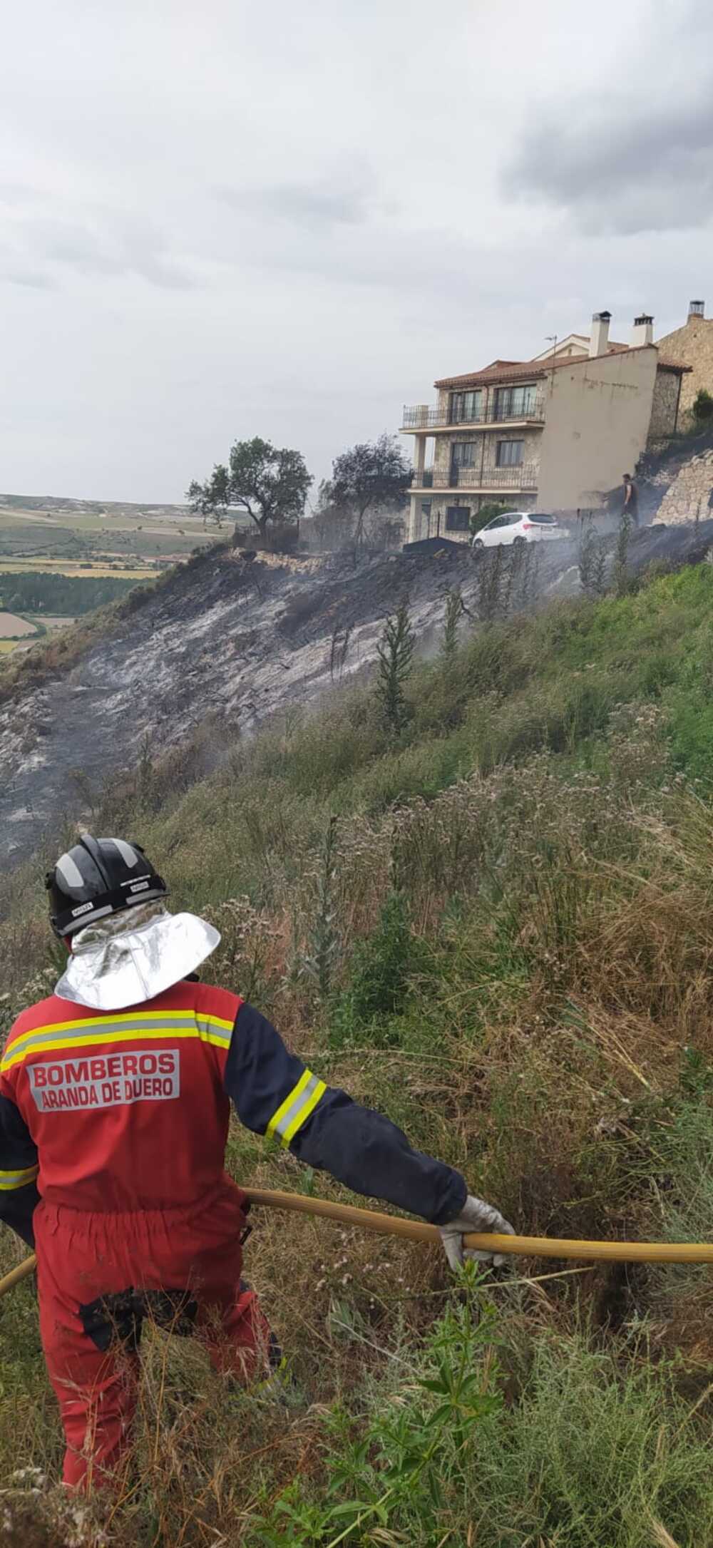 Un bombero observa cómo el fuego se acercó demasiado a las viviendas.