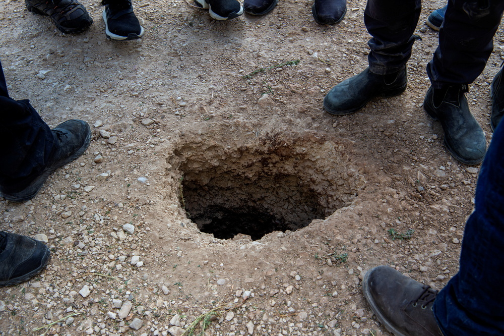 Varias personas se colocan en torno al agujero por el que escaparon los presos