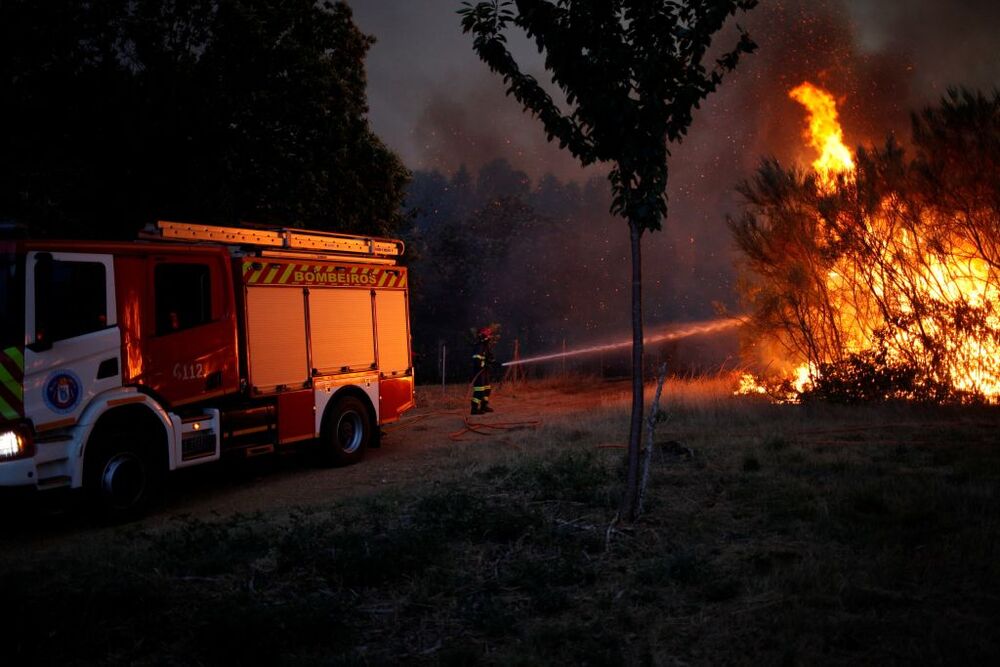 A firefighter works to extinguish a wildfire in Verin