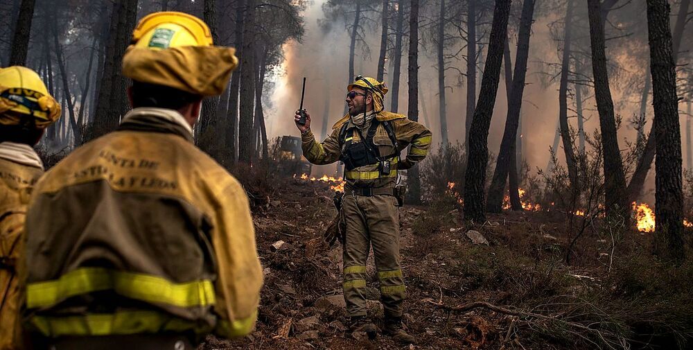Varios de los bomberos que trabajan en los incendios de Zamora reciben instrucciones en uno de los focos en la Sierra de la Culebra. 