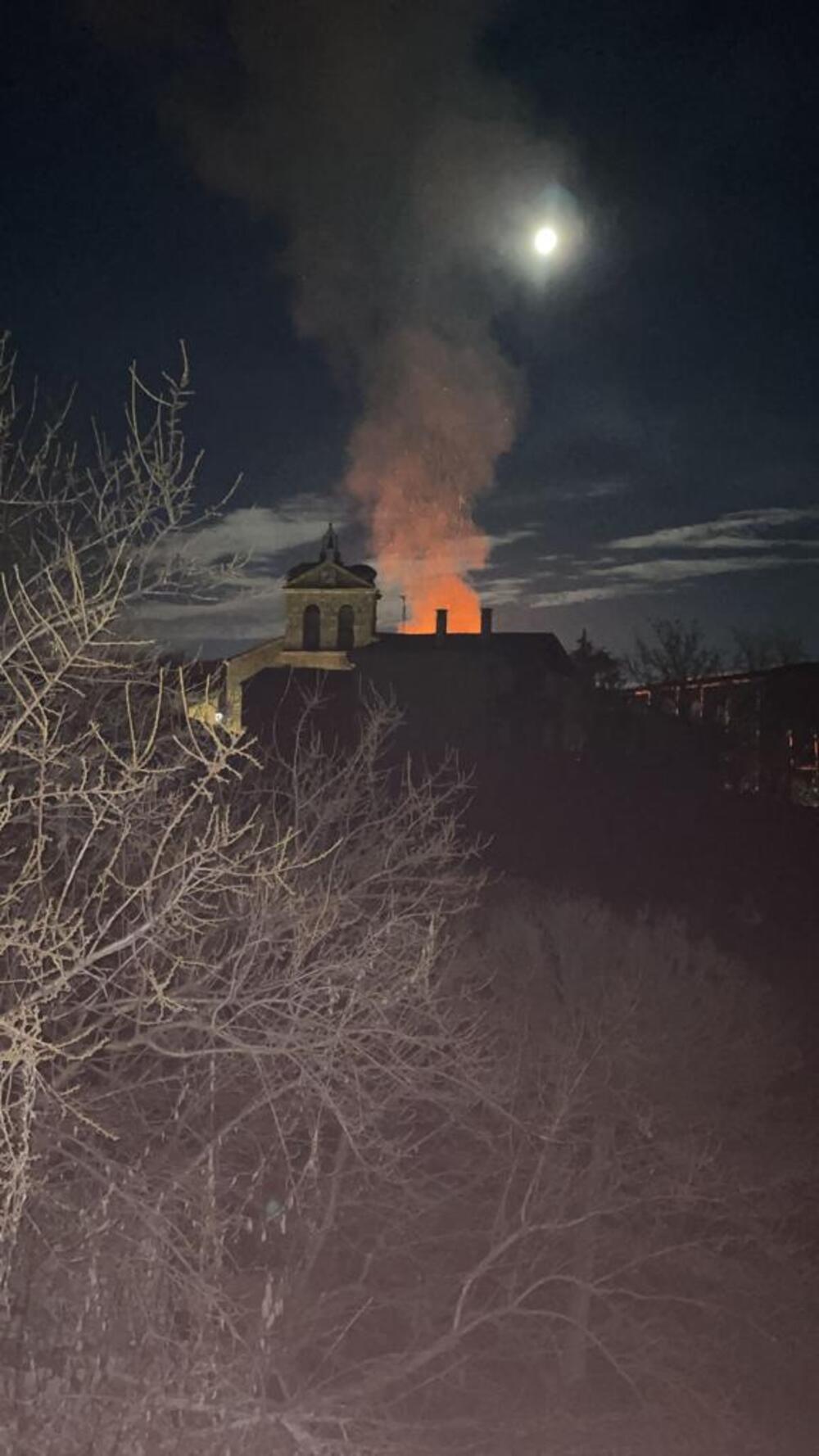 El fulgor de las llamas se refleja en la torre y el humo se eleva por encima de ella.  / DB