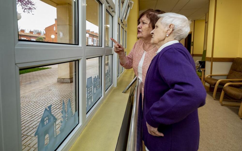 Soledad y su madre, Matilde, miran por la ventana en uno de los días que Burgos amaneció bajo la calima.