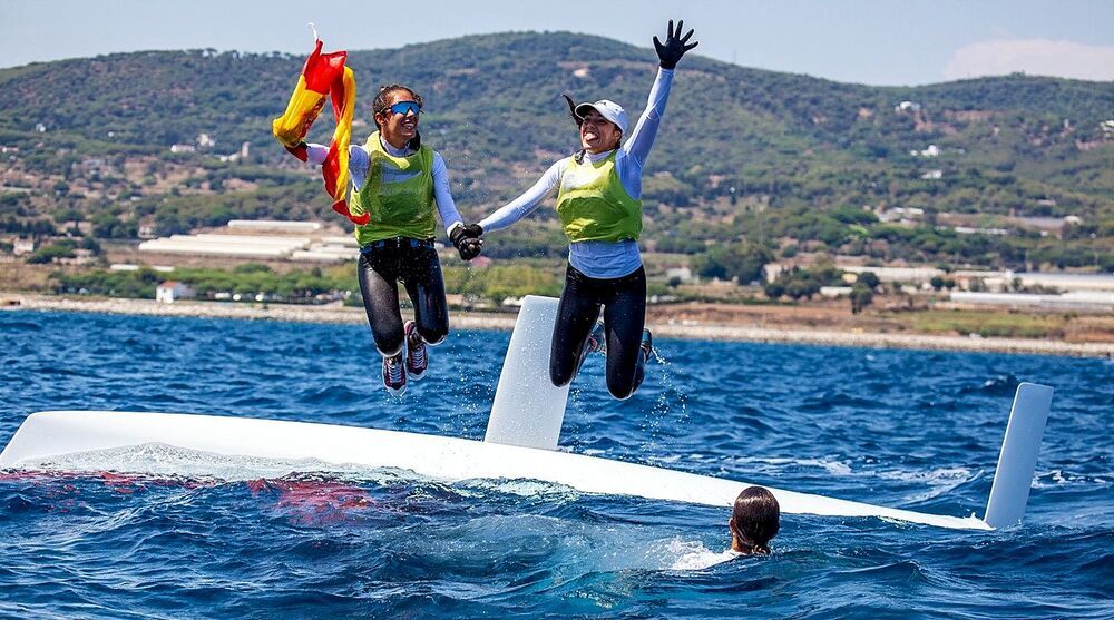 Isabel y Paula celebran el título con la bandera española en aguas de Barcelona. 