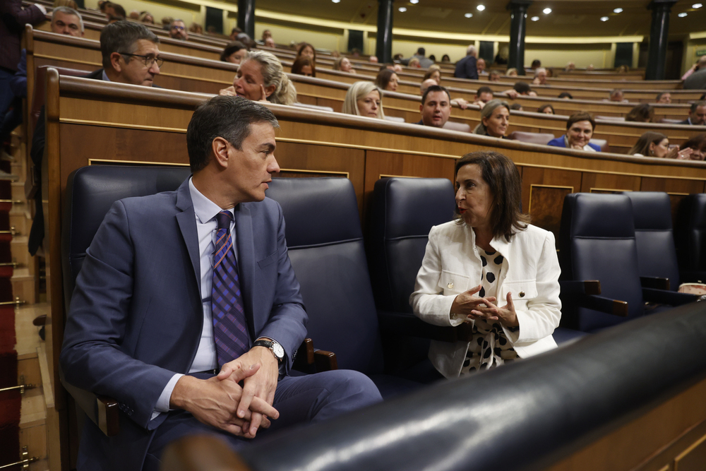 El presidente del Gobierno en funciones Pedro Sánchez (i) conversa con la ministra de Defensa, Margarita Robles (d), durante el pleno del Congreso.