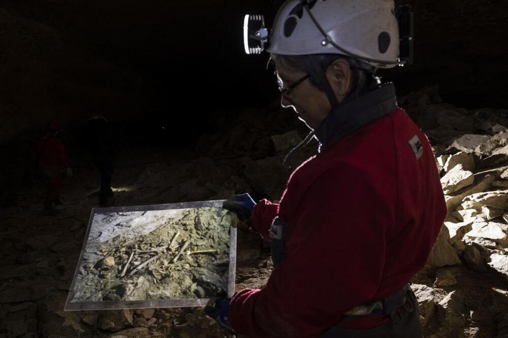 La arqueólogo Ana Isabel Ortega muestra una imagen con los restos de uno de los individuos encontrados en Cueva Palomera.