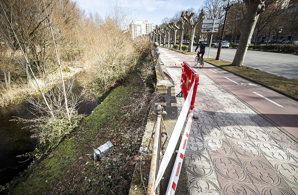 Desde hace meses, una cinta de bomberos protege la valla que se ha caído junto al río. 