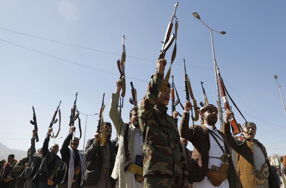 Combatientes hutíes sostienen armas y corean consignas en una ceremonia al final de su entrenamiento en Sanaa